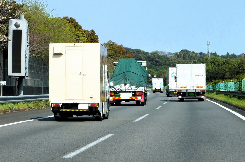 東名高速道路を走るトラックの列